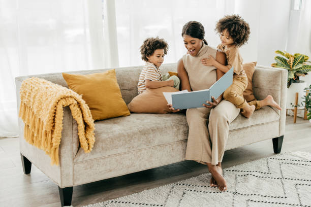 istock Mother reading a book for twins 1358084214