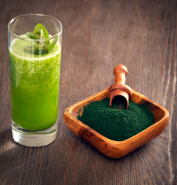 istock Green smoothie with spirulina on wood background 1358084274