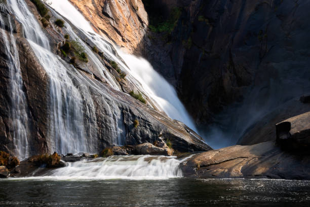 istock Ezaro waterfall water crashing on lake between rocks in Spain 1358084372