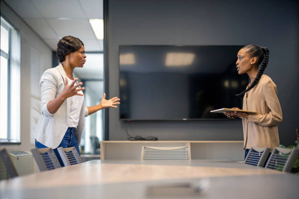 istock Female boss shouting at employee in boardroom 1358085083
