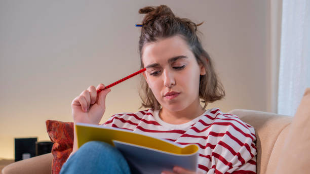 istock View of a young female who is studying. She is thinking deeply. She is doing her homework. 1358085955