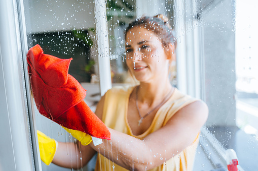 Young woman washing window stock photo