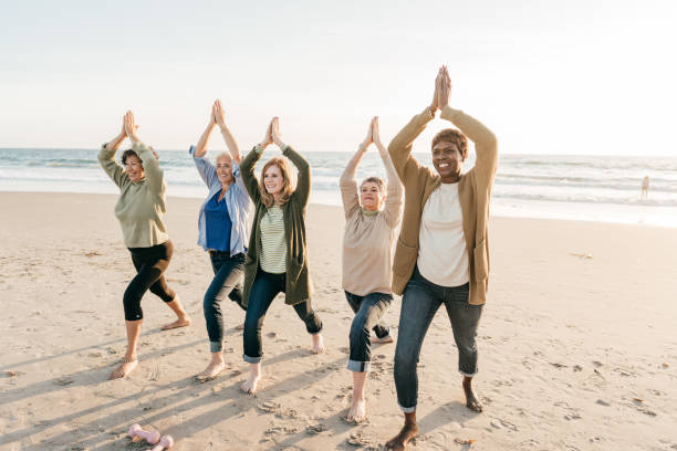 istock Joyful yoga on the beach  with seniors 1358087536