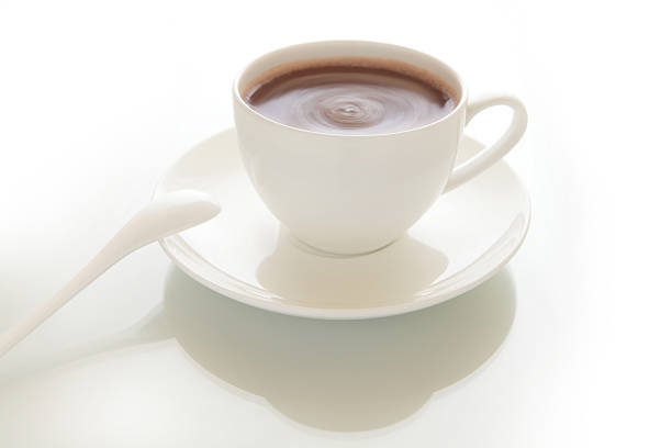 A full turkish coffee cup with an hand on blurred background