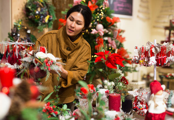 istock Asian woman chooses a Christmas composition with candles 1358090806