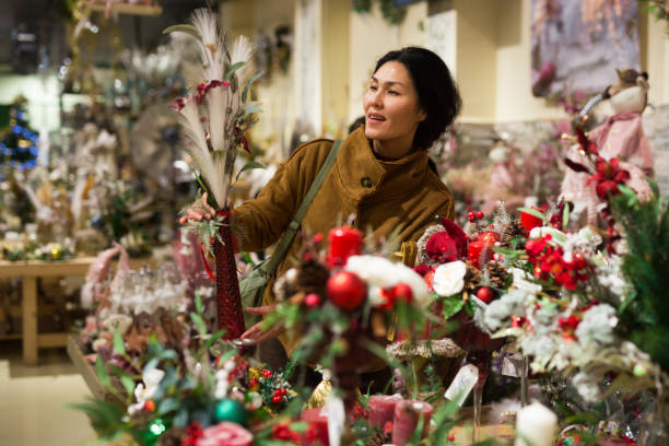 istock Positive asian woman chooses a Christmas composition 1358090818