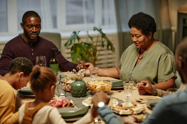 familia orando en la cena - family thanksgiving dinner praying fotografías e imágenes de stock