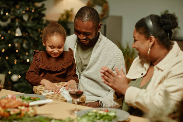 istock Little Girl Opening Christmas Present 1358090854
