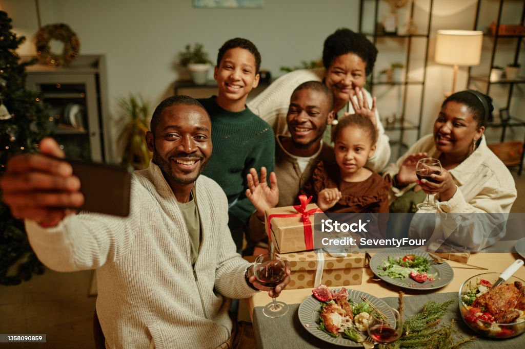 African American Family Taking Selfie at Christmas High angle portrait of happy African-American family taking selfie photo while enjoying Christmas at home together Family Stock Photo