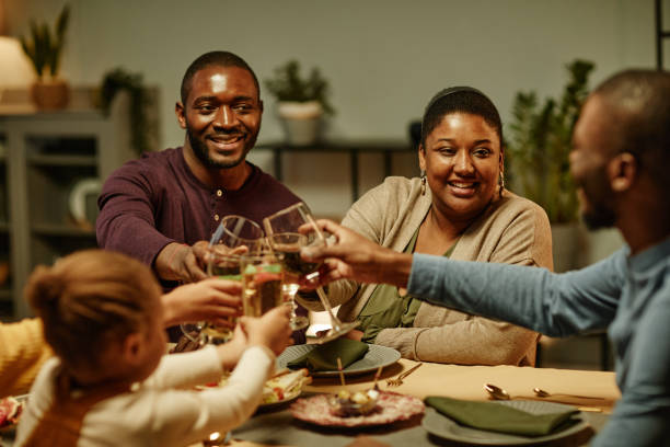 black family celebrating - wine dinner party drinking toast imagens e fotografias de stock