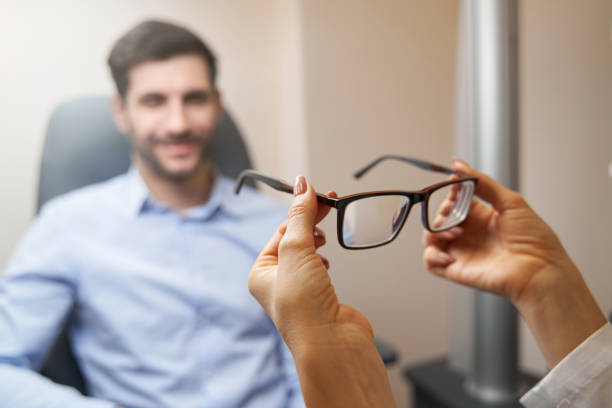istock Optometrist bringing pair of glasses to patient 1358091542