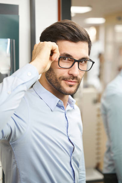istock Caucasian man staring at camera while trying new eyeglasses 1358091549