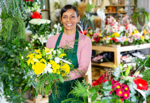 istock Woman florist in apron arranging bouquet 1358091699