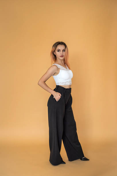 istock beautiful pretty young girl posing for a portrait on a solid peach background. 1358094785