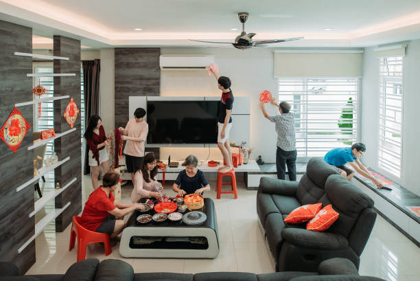 Aisan chinese family decorating their living hall during chinese new year eve stock photo