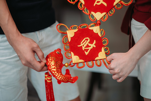 close up of couple hands holding chinese ornaments