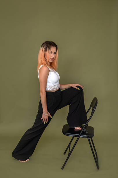 istock beautiful well-groomed woman posing boldly on a solid green studio background. 1358097590