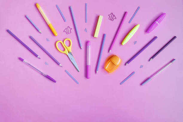 istock Violet and yellow stationery on pink. Flat lay. 1358098900