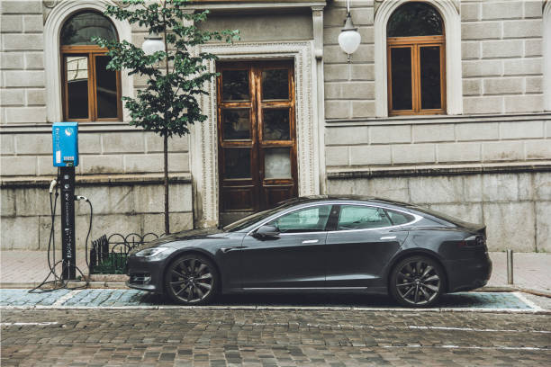 Tesla Model S in the city. An electric car is being charged in the city stock photo