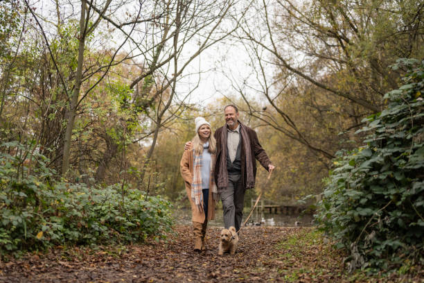 istock Happy couple with terrier enjoying weekend walk in park 1358103638