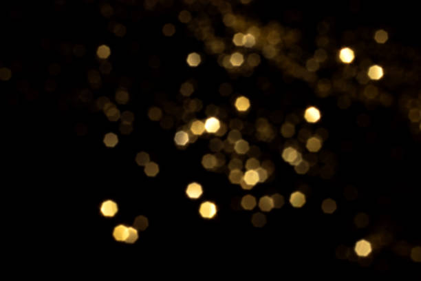 istock Golden blurred bokeh lights on black background 1358103808