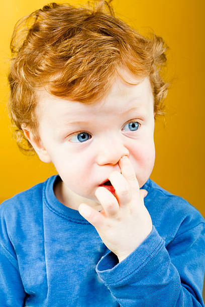 istock child with redhead and finger in hte nose 135810556