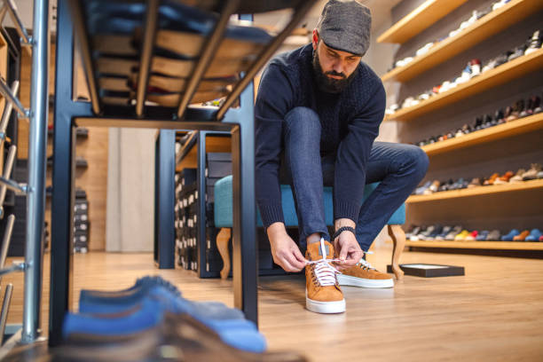istock Young man trying on shoes in a store 1358106627