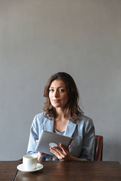 istock Gorgeous woman sitting indoors using tablet computer. 1358107531
