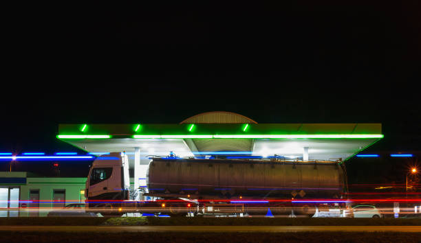 reabastecimento de caminhões em posto de gasolina com tráfego de movimento na cidade à noite. longa exposição da luz do carro, república tcheca - truck oil industry natural gas action - fotografias e filmes do acervo