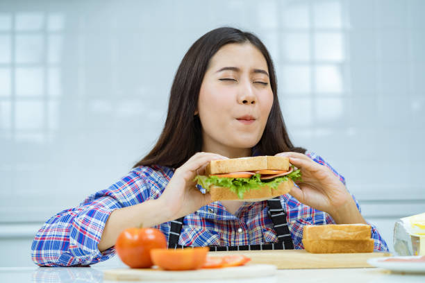 istock asian woman happy make sandwich. 1358108053