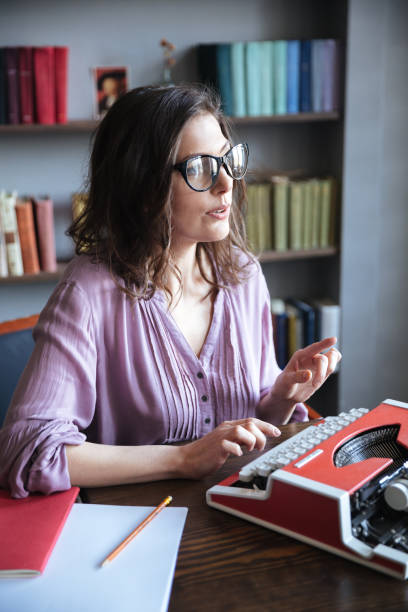 istock Woman journalist in eyeglasses typing on typewriter indoors 1358108112