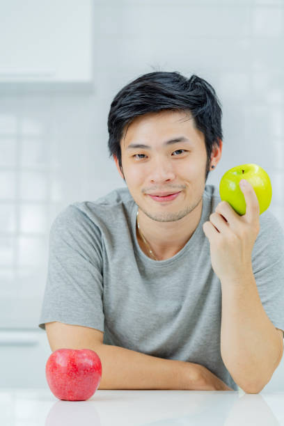 istock Asian man eating an apple. 1358108971