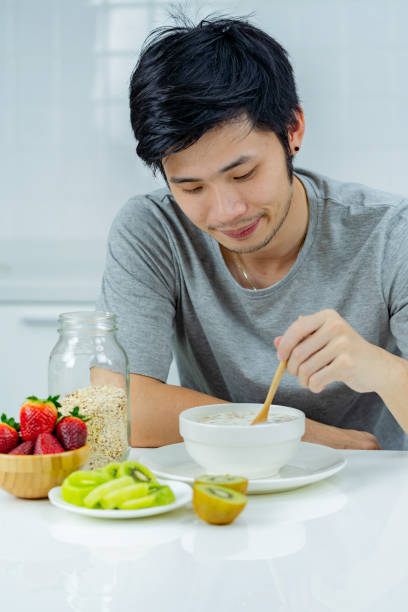 istock Asian man eating oatmeal for breakfast 1358108986