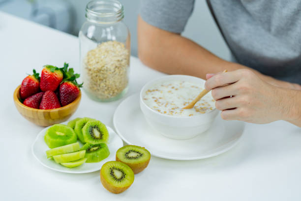 Asian man eating oatmeal for breakfast