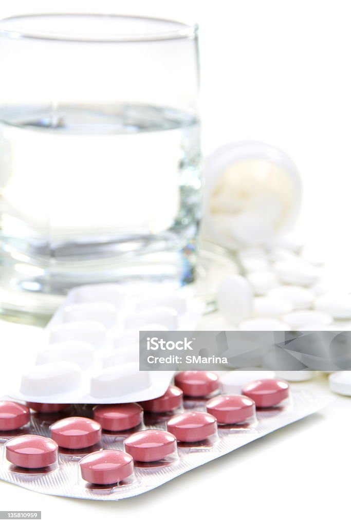 Different pills and glass of water Different pills and glass of water on a white background. Blister Stock Photo