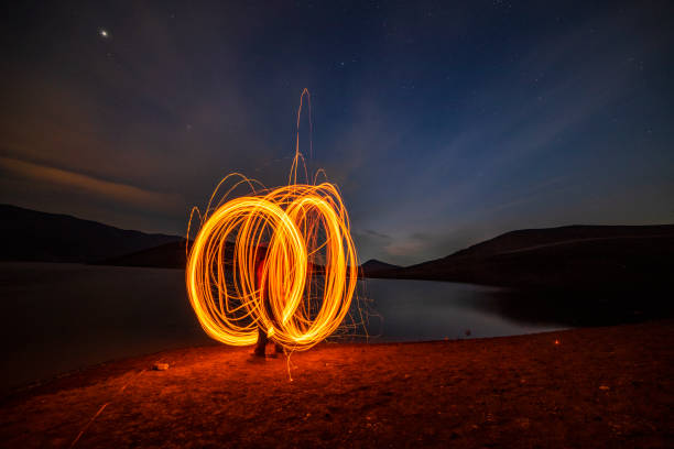 istock Still wool fire show on the lake shore. Night landscape. 1358109741