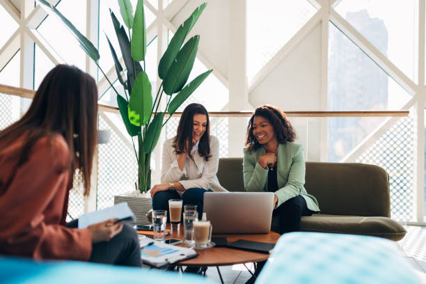 istock Female work colleagues chatting over coffee 
in a modernly equipped office, next to the window. 1358110407