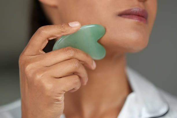 istock Shot of a beautiful woman using a scraping tool on her face 1358110724