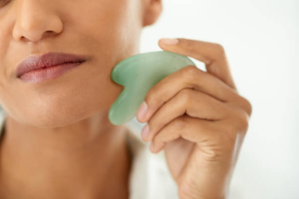 istock Closeup shot of a beautiful woman using a scraping tool on her face 1358110727