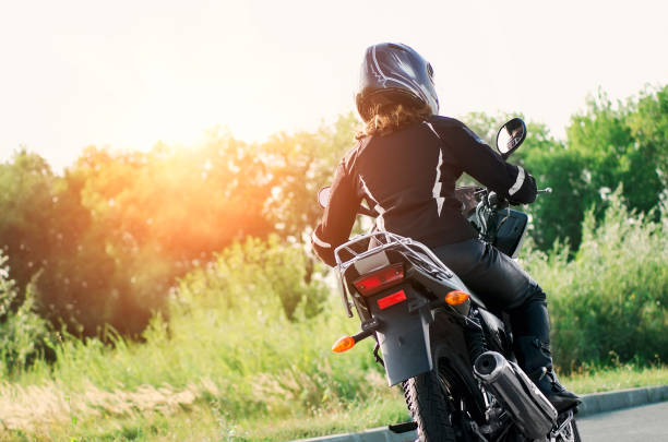 istock Biker girl in a leather jacket and helmet on a motorcycle 1358112337
