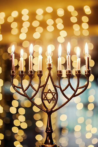 A brightly lit Menorah with glowing candles for Hanukkah holiday season.