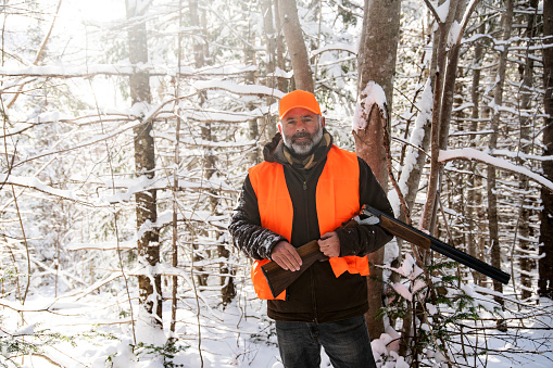 A mature man out hunting on a snowy winter day. Photographed in North America.