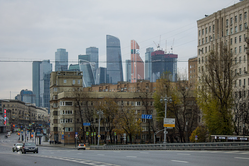 panoramic view of Stalinist architecture on Kutuzovsky Prospekt and modern skyscrapers of Moscow City on a cloudy autumn day and the roadway with cars in Moscow