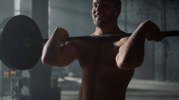istock Man lifting weights in gym. Strong guy shoulder press exercise during training 1358126157
