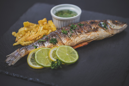 Grilled trout with french fries,lemon and vegetable
