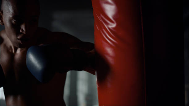 istock Athlete practicing kickboxing in fighting club. Energetic man training punches 1358127348