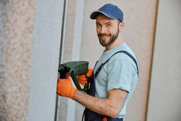 istock Cheerful male builder drilling wall with electric drill 1358127619