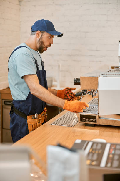 istock Shocked repairman fixing coffee machine in cafe 1358129802