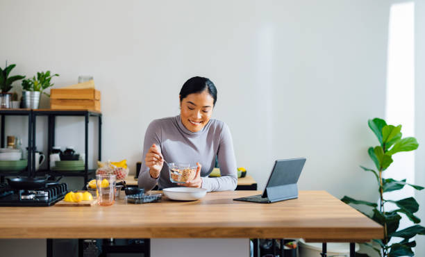 istock Cheerful Woman Making Healthy Breakfast in Kitchen 1358132382