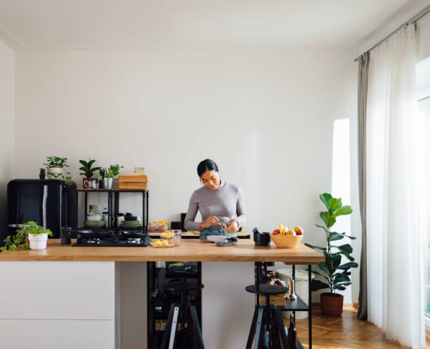 istock Smiling Woman Making Healthy Breakfast in Kitchen 1358132383